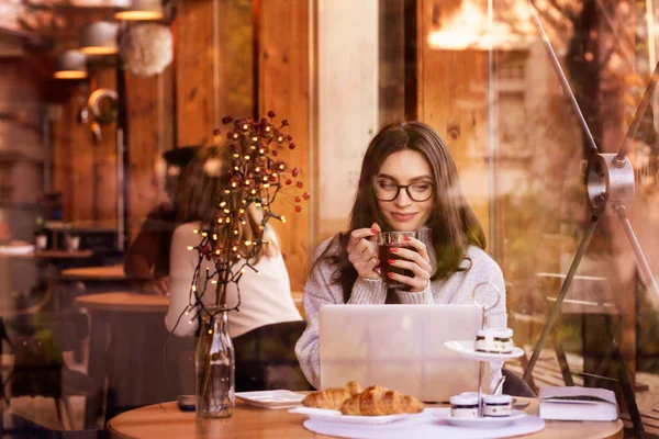 在网上遇见一个微笑的女人 在咖啡店边喝茶边上网 — 图库照片