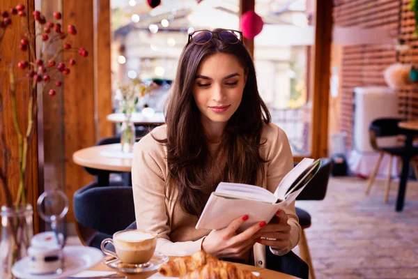 在咖啡馆休息时读书的漂亮女人的画像 — 图库照片