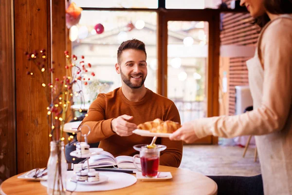 Hombre Feliz Sentado Escritorio Mientras Camarera Trae Croissant Cafetería — Foto de Stock