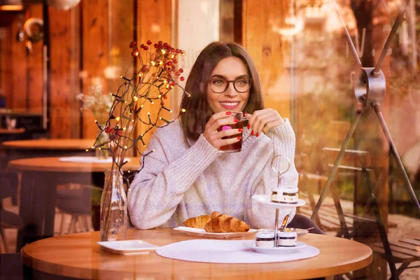 一个漂亮女人坐在餐桌旁 在咖啡店喝茶的画像 — 图库照片