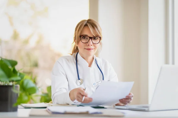 Retrato Tiro Maduro Masculino Médico Sentado Mesa Fazendo Alguns Papelada — Fotografia de Stock