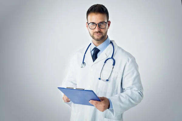 Retrato Estudio Joven Médico Varón Sosteniendo Portapapeles Mano Mientras Estaba — Foto de Stock