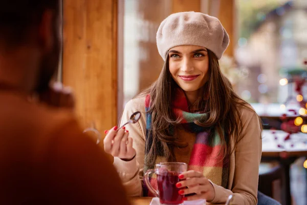 カフェでテーブルに座ってお茶を飲みながら帽子とスカーフを被った美しい女性の肖像画 — ストック写真