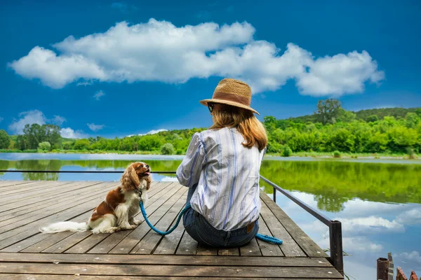 Vista Trasera Mujer Sentada Junto Lindo Cachorro Caballería Spaniel Muelle —  Fotos de Stock