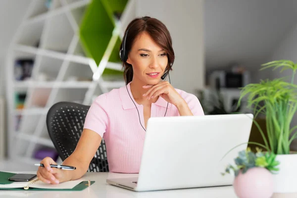 Kundendienstassistentin Mit Headset Während Sie Hinter Ihrem Laptop Sitzt Und — Stockfoto