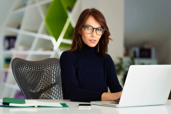 Empresária Meia Idade Confiante Sentada Mesa Escritório Atrás Seu Laptop — Fotografia de Stock