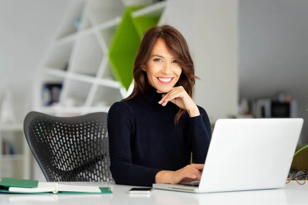 Pewna Siebie Bizneswoman Średnim Wieku Swetrze Turtleneck Siedząc Biurze Laptopem — Zdjęcie stockowe