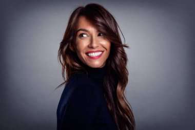 Gri arka planda beyaz dişli, gülümseyen güzel bir kadın. Balıkçı yaka kazak giyen mutlu kadın. Boşluğu kopyala.