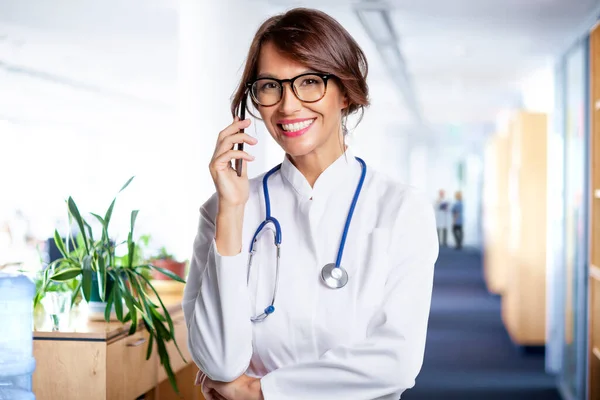 Mosolygó Doktornő Aki Telefonál Miközben Kórházban Áll — Stock Fotó