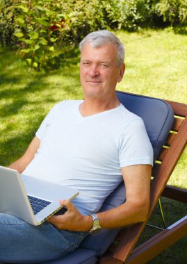 Dizüstü bilgisayarı olan yaşlı bir adam.