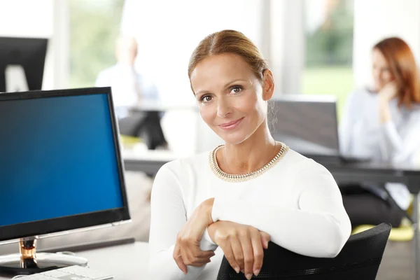 Reife Geschäftsfrau sitzt im Büro — Stockfoto