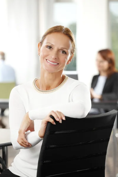 Femme d'affaires mature assise au bureau — Photo