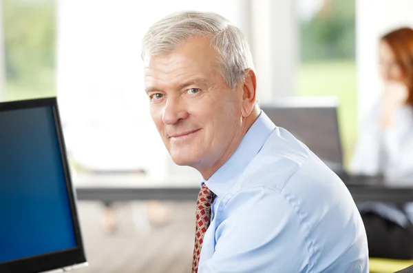 Senior-Geschäftsmann sitzt im Büro — Stockfoto