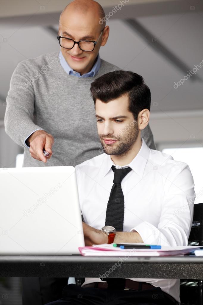 Business people analyzing data on computer