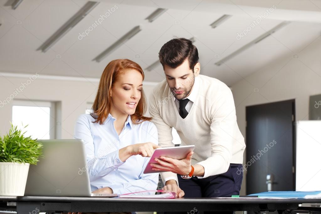 Businessman with tablet discussing with businesswoman