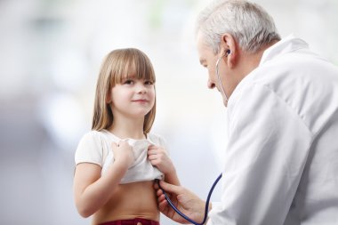 Doctor checking heartbeat of girl clipart