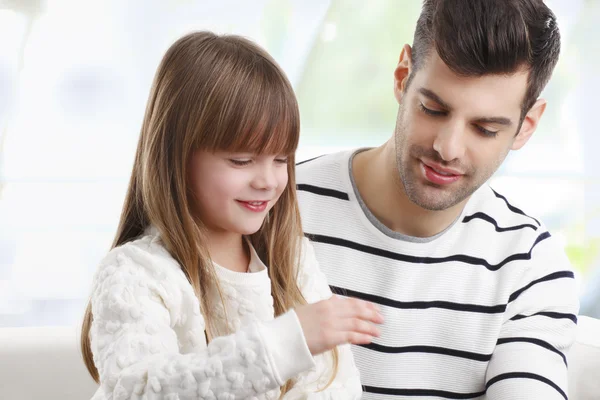 Mädchen und Vater sitzen auf Sofa — Stockfoto