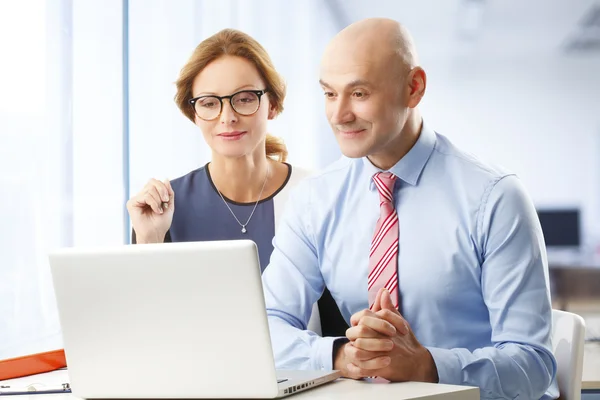 Businesswoman and businessman working on laptop — Stock Photo, Image