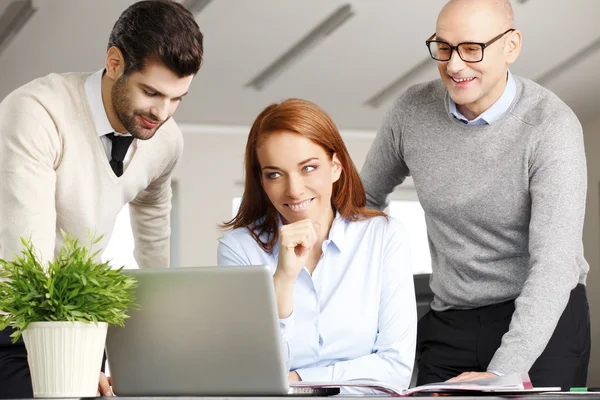 Empresária e seus colegas analisando dados — Fotografia de Stock