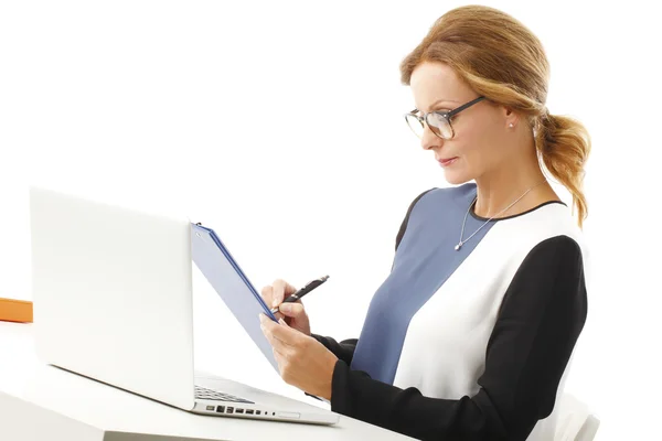 Zakenvrouw met laptop schrijven van notities — Stockfoto