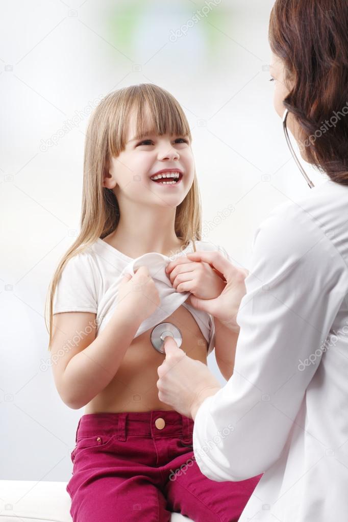 Doctor listening heartbeat of girl