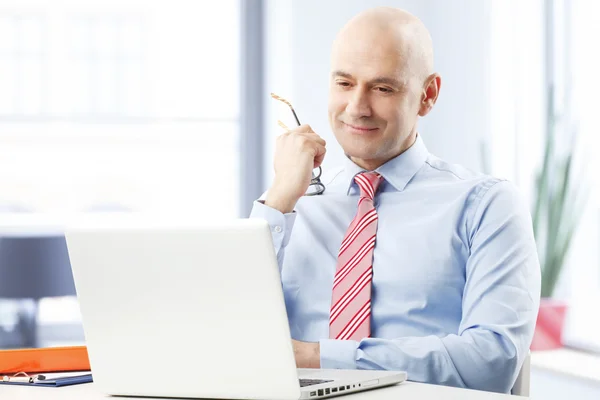 Businessman reading report on laptop — Stock Photo, Image