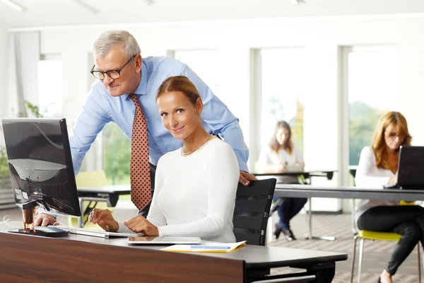 Businessman giving advise to sales woman — Stock Photo, Image