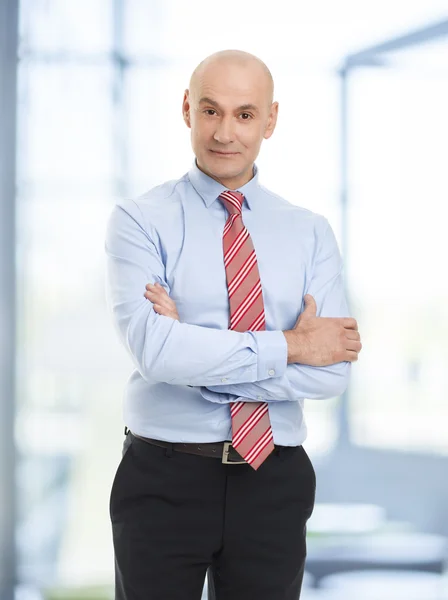 Zakenman met gekruiste op kantoor armen — Stockfoto