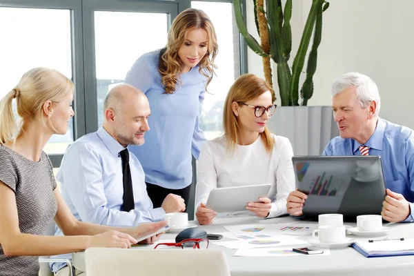 Businesswomen and businessmen around conference table — Stock Photo, Image