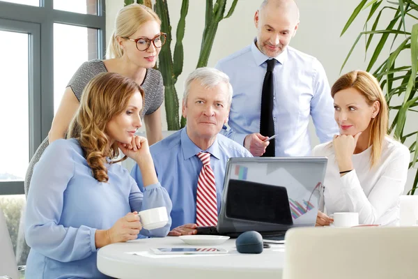 Businesswomen and businessmen around conference table — Stock Photo, Image