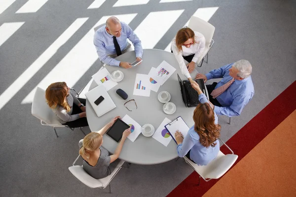 Pessoas de negócios sentadas em torno da mesa — Fotografia de Stock