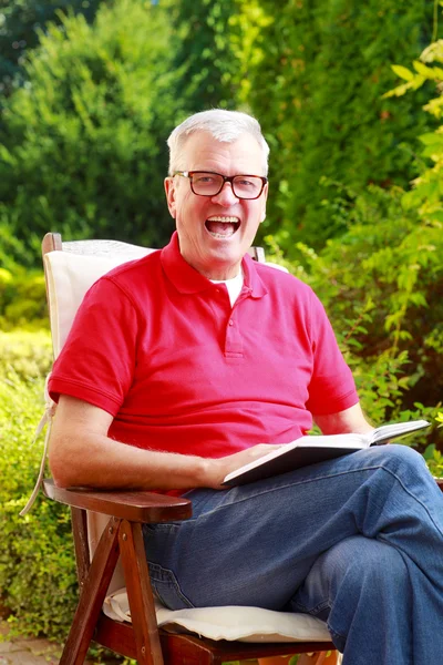 Man  reading book and laughing — Stock Photo, Image