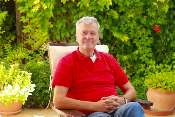 Man sitting in garden at home — Stock Photo, Image