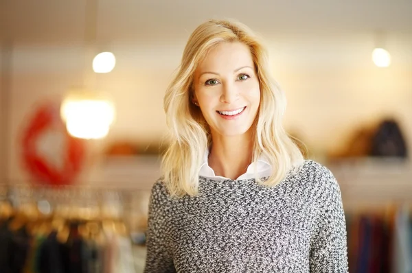 Donna in piedi nel suo negozio di abbigliamento — Foto Stock