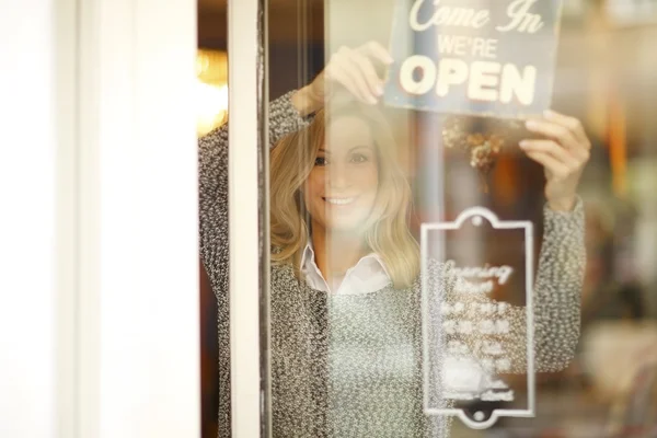 Femme debout derrière son magasin de vêtements — Photo