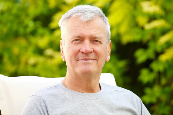 Senior man sitting at garden — Stock Photo, Image