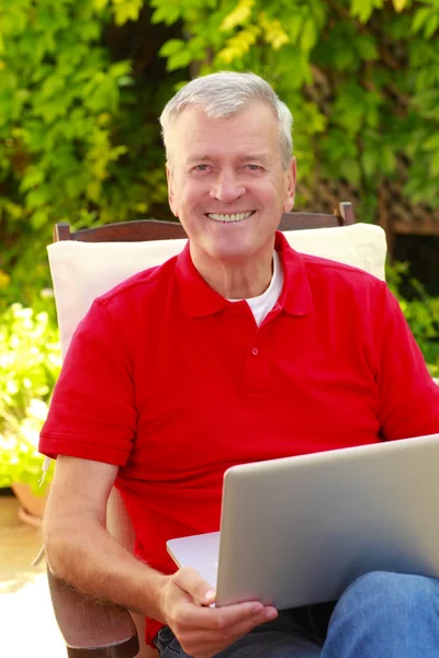 Zakenman in tuin en bezig met laptop — Stockfoto