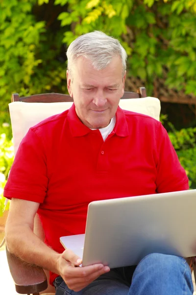 Ο άνθρωπος στο κήπο και χρησιμοποιώντας φορητό υπολογιστή — Φωτογραφία Αρχείου