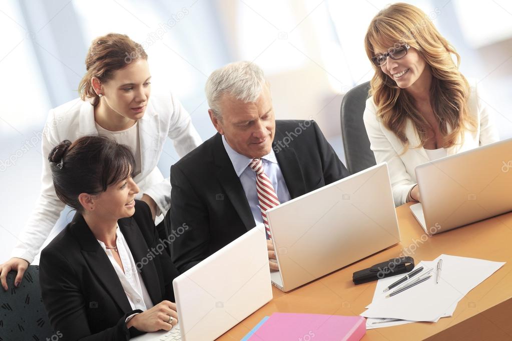 businesswomen and businessman at office desk