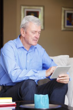 man sitting at sofa with tablet