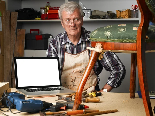 Carpenter points out of laptop — Stock Photo, Image