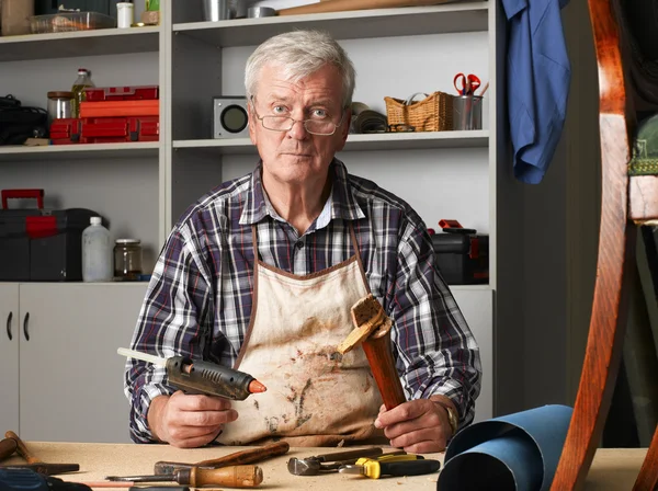 Retired carpenter sitting at workshop — Stockfoto