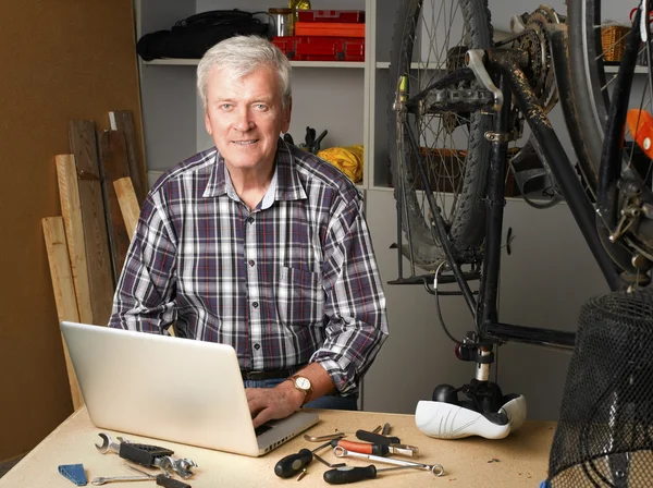 Retired man sitting in front of laptop — Stockfoto