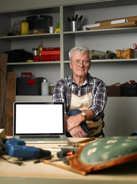 Craftsman sitting behind the laptop — Stock fotografie