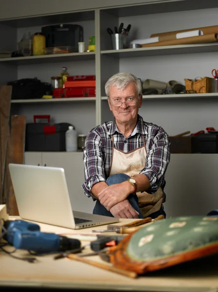 Столяр на пенсии сидит в мастерской — стоковое фото