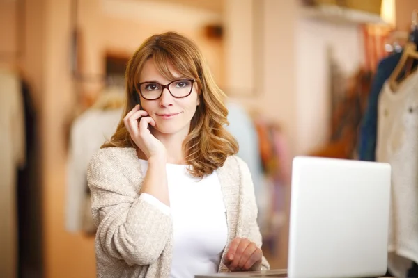 Clothing store owner woman making call — Stockfoto