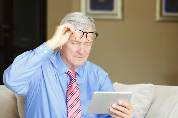 Senior man die digitale tablet gebruikt — Stockfoto