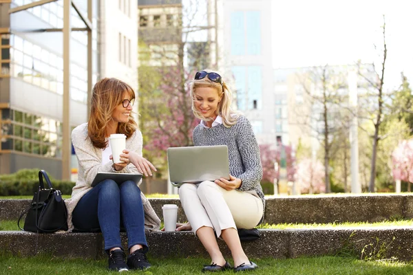 Businesswomen at park while using tablet — Stockfoto