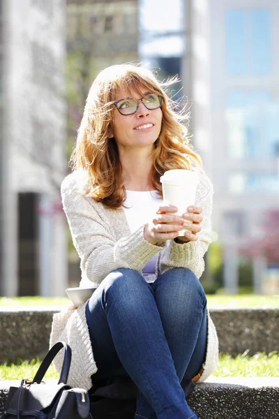 Woman at park drinking coffee — ストック写真