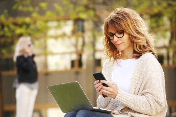 Vrouw zitten in het businesspark en het gebruik van laptop — Stockfoto